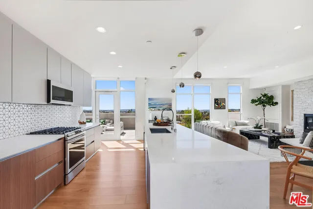 a large white kitchen with lots of counter space a sink and appliances
