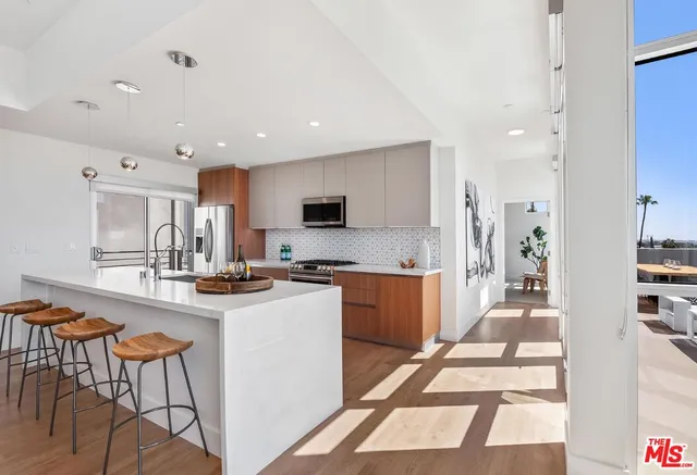 a kitchen with stainless steel appliances kitchen island granite countertop a refrigerator and a stove top oven