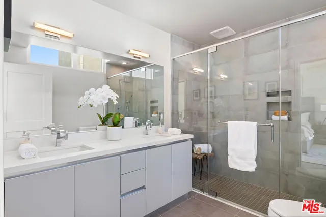 a bathroom with a double vanity sink mirror and shower
