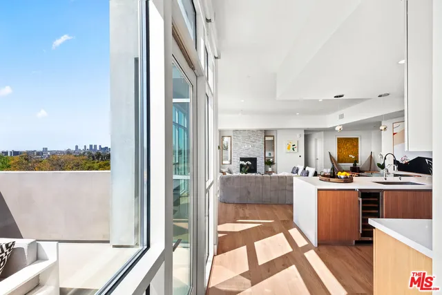 a living room with stainless steel appliances granite countertop furniture and a view of kitchen
