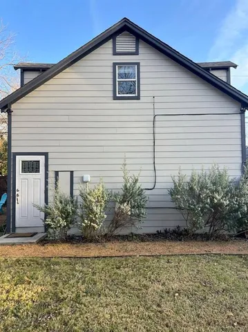 a view of a house with a yard and potted plants