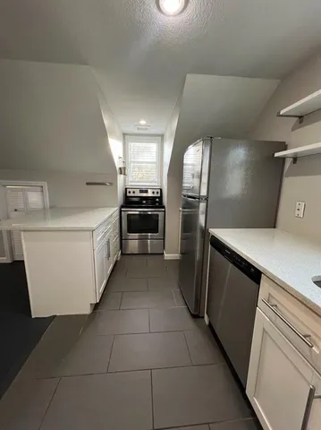 a kitchen with a refrigerator and a stove