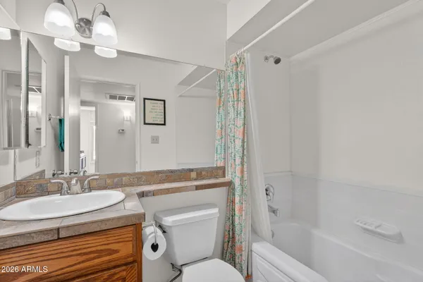 a bathroom with a granite countertop sink a toilet and shower