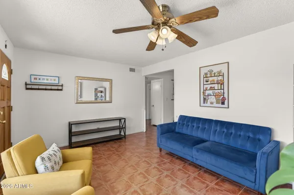 a living room with a couch and a ceiling fan