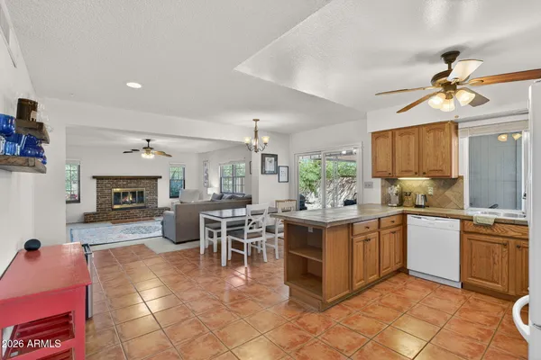 a kitchen with stainless steel appliances granite countertop a stove top oven a sink a dining table and chairs with the front of the kitchen