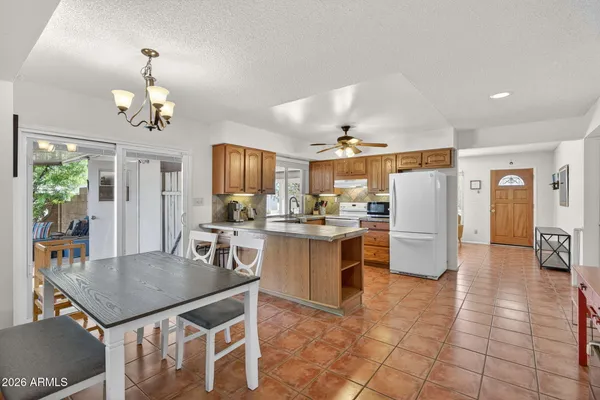 a kitchen with a table chairs microwave and refrigerator