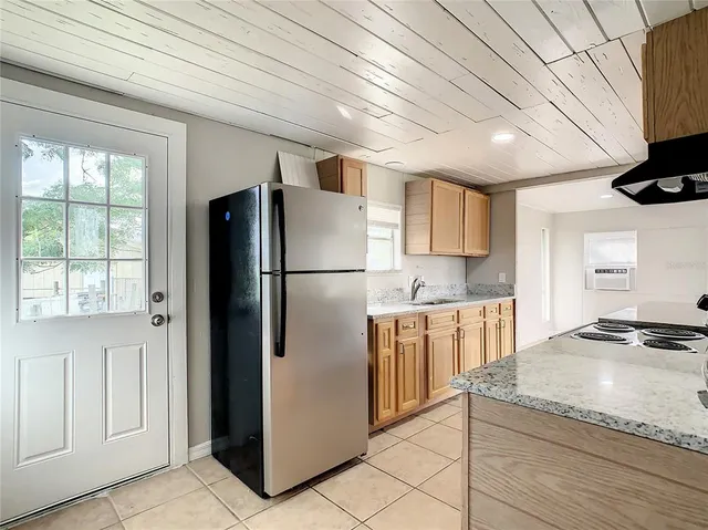 a kitchen with granite countertop a refrigerator and a stove