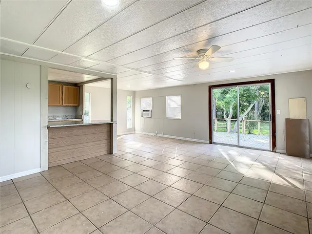 a view of empty room with windows and refrigerator