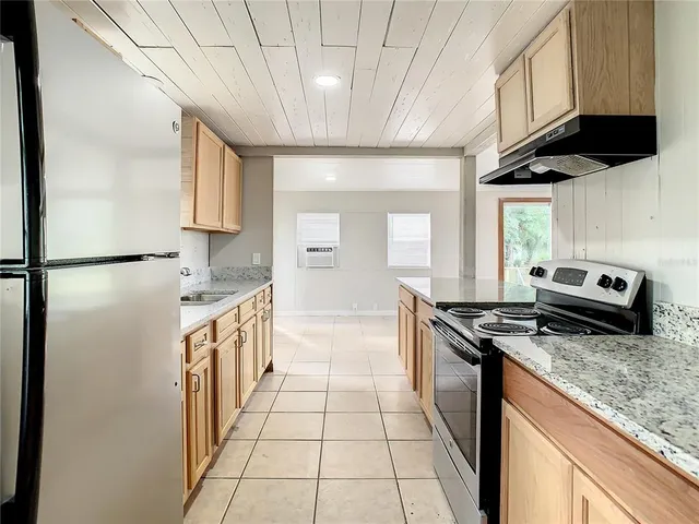 a kitchen with stainless steel appliances granite countertop a stove a sink and a refrigerator