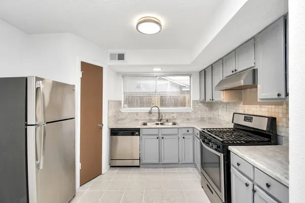 a kitchen with a sink a stove and refrigerator