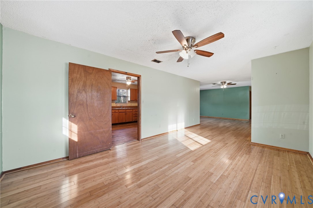 3881 Strawberry Plains Road Williamsburg, VA 23188 - Photo 12 of 29 a view of empty room with wooden floor and fan