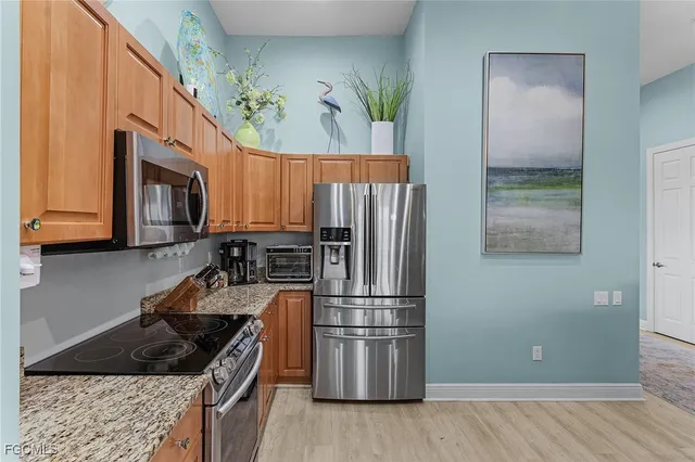 a kitchen with granite countertop a refrigerator stove and microwave