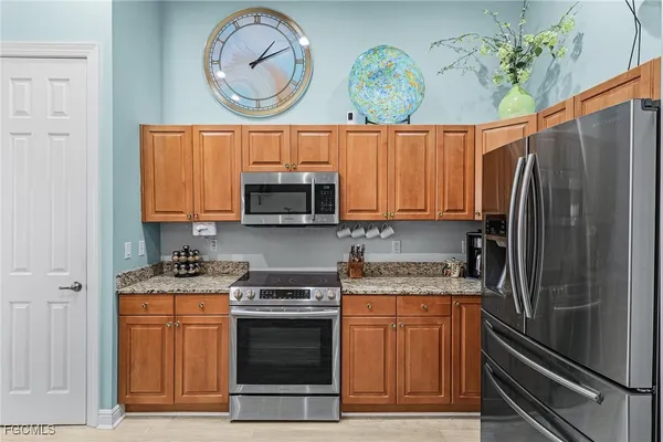 a kitchen with stainless steel appliances granite countertop a stove a sink and a refrigerator