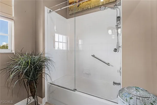 a bathroom with a shower and a glass door