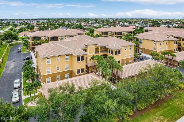 an aerial view of residential houses with outdoor space and parking