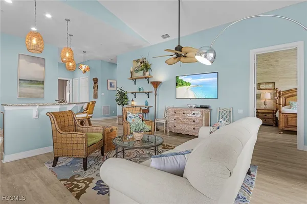 a living room with dining room and a chandelier
