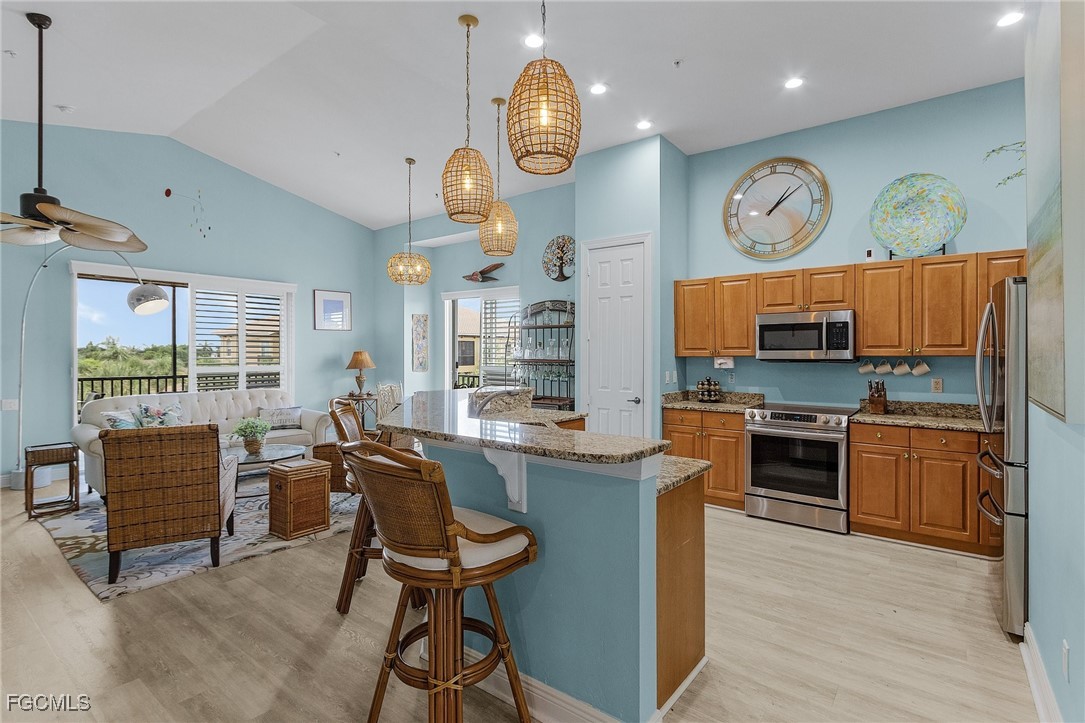3728 Agualinda Boulevard, Unit 304 Cape Coral, FL 33914 - Photo 8 of 25 a kitchen with stainless steel appliances granite countertop a stove and a refrigerator