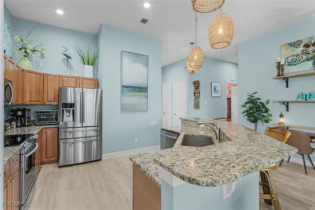 a kitchen with stainless steel appliances granite countertop a sink refrigerator and microwave