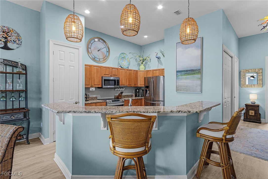 3728 Agualinda Boulevard, Unit 304 Cape Coral, FL 33914 - Photo 10 of 25 a view of a kitchen with fridge and outdoor seating