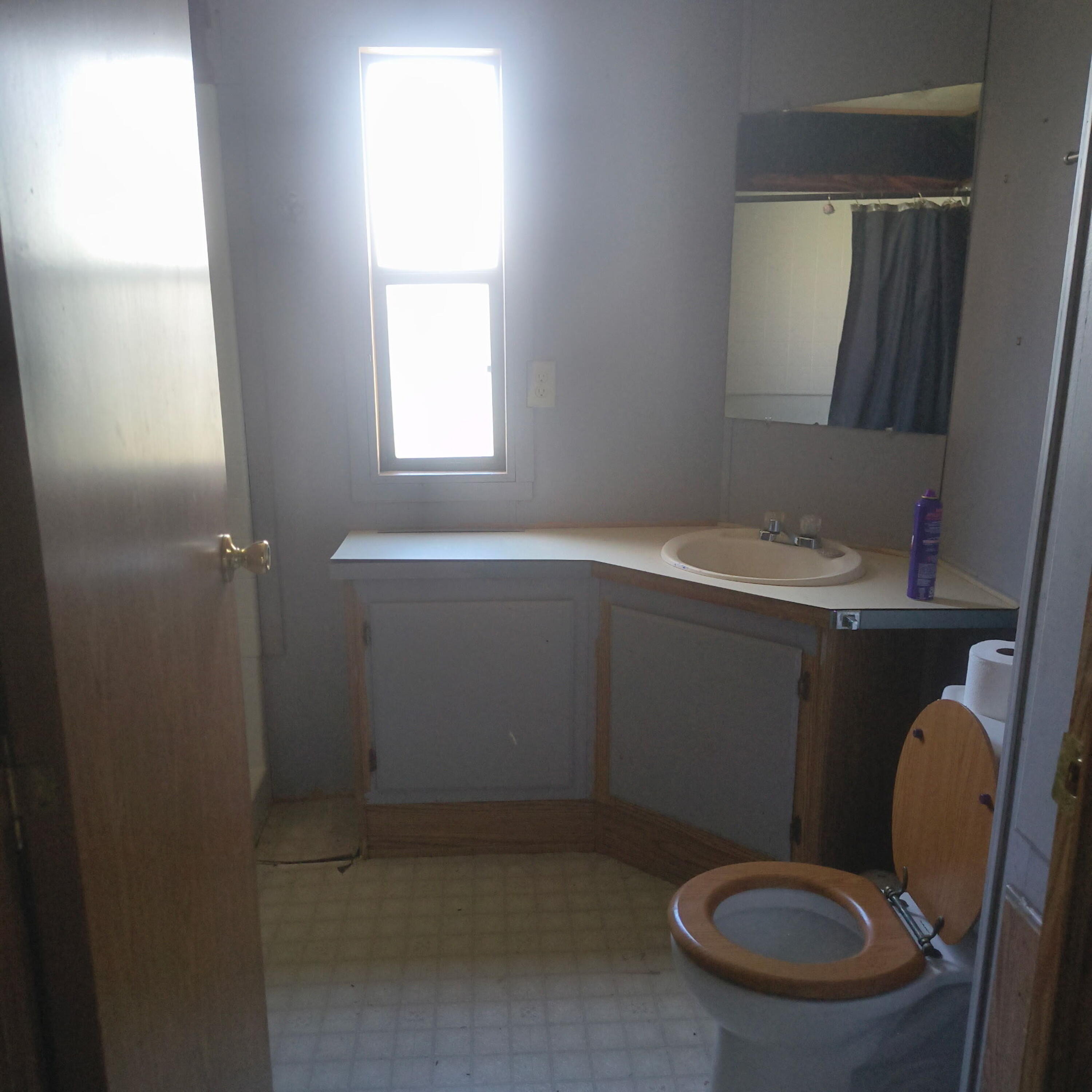 222 Ollis Road, Unit 24 Cave Junction, OR 97523 - Photo 5 of 6 a bathroom with a granite countertop toilet a sink and mirror