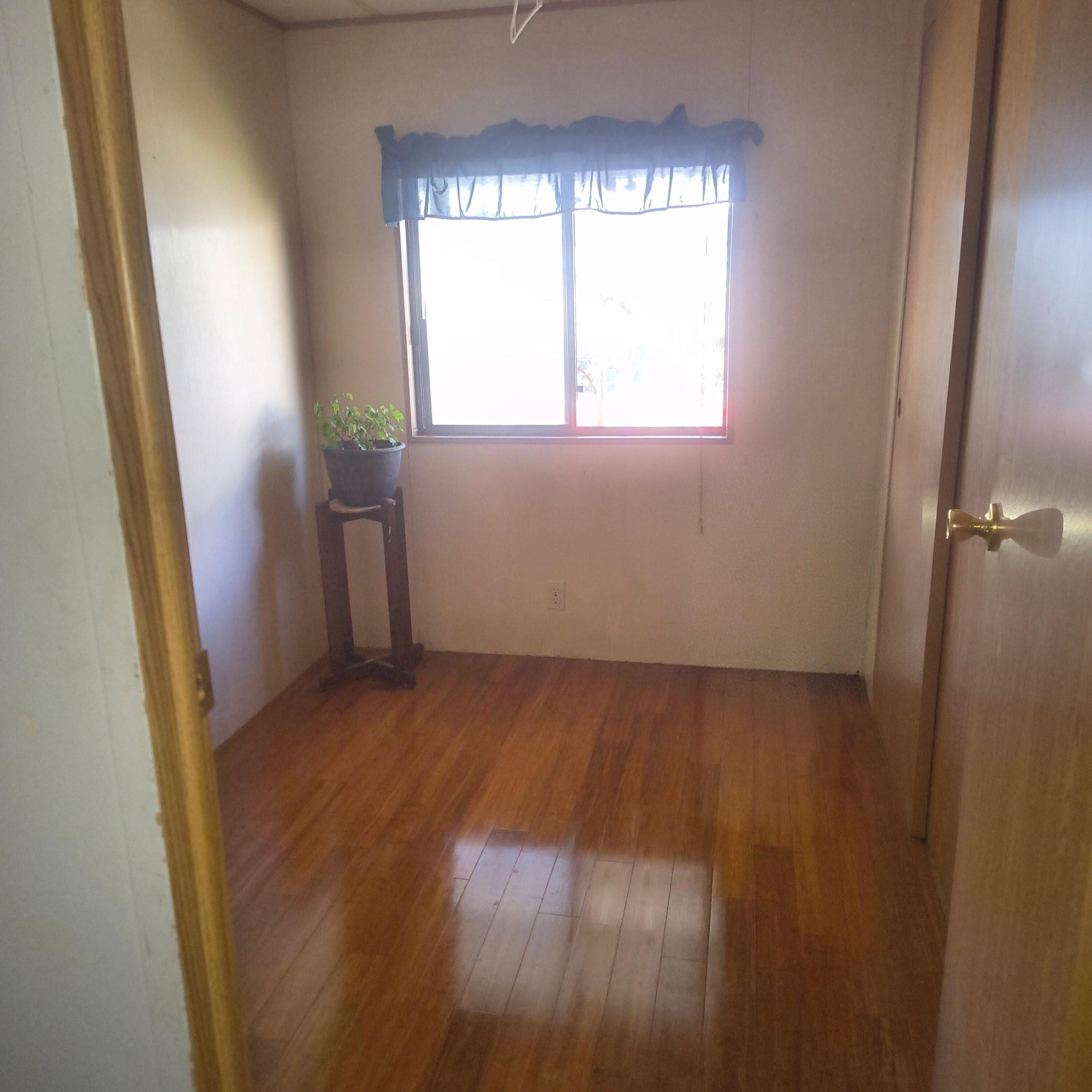222 Ollis Road, Unit 24 Cave Junction, OR 97523 - Photo 6 of 6 an empty room with wooden floor and windows