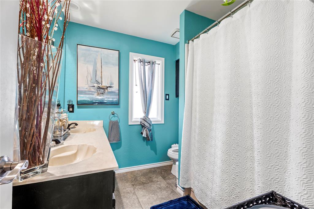 3910 Kingsferry Court Arlington, TX 76016 - Photo 21 of 32 a bathroom with a sink a toilet and shower curtain