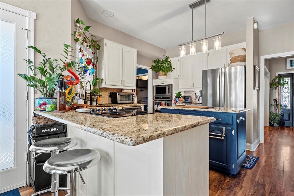3910 Kingsferry Court Arlington, TX 76016 - Photo 9 of 32 a kitchen with stainless steel appliances granite countertop a sink a stove and a wooden floors