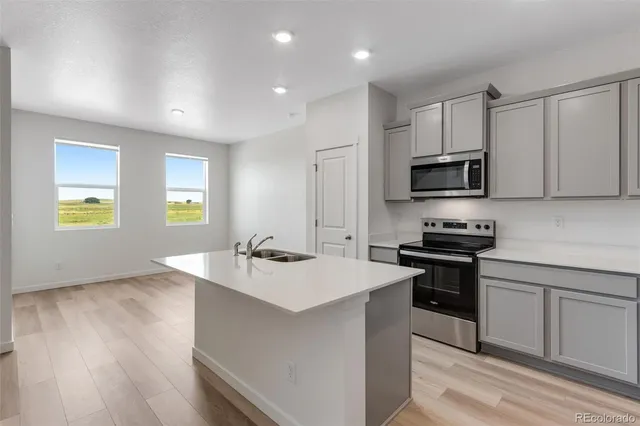 a kitchen with kitchen island white cabinets appliances and a sink