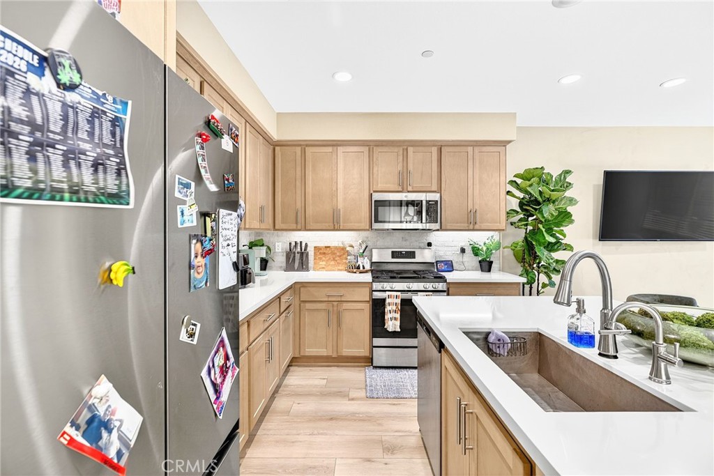 39400 Corvina Lane Temecula, CA 92591 - Photo 15 of 42 a kitchen with granite countertop a sink a counter top space appliances and cabinets