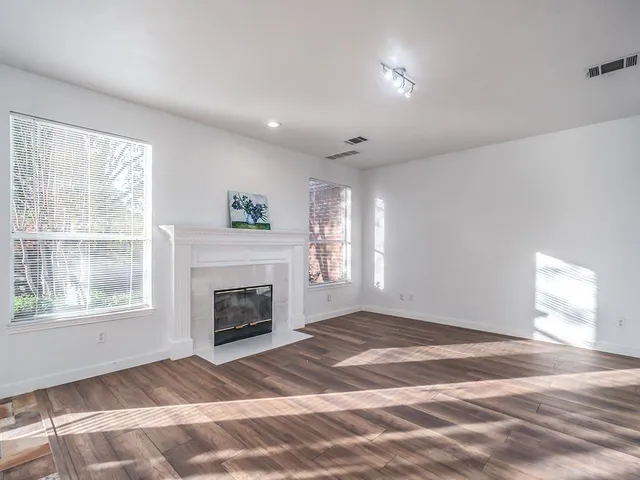a view of an empty room with window and fire place