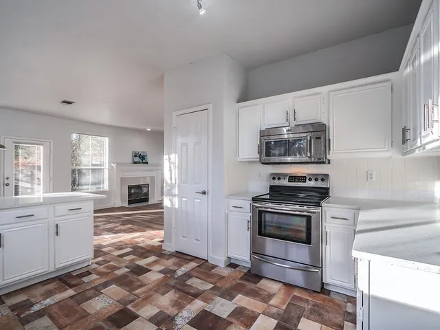 a kitchen with stainless steel appliances granite countertop a stove a sink and a refrigerator
