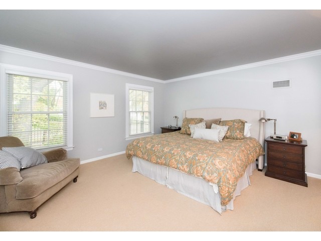 764 Locust Street Winnetka, IL 60093 - Photo 10 of 25 a spacious bedroom with a bed and a couch with window