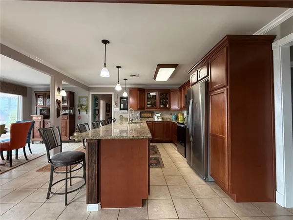 a kitchen with a dining table chairs sink and cabinets