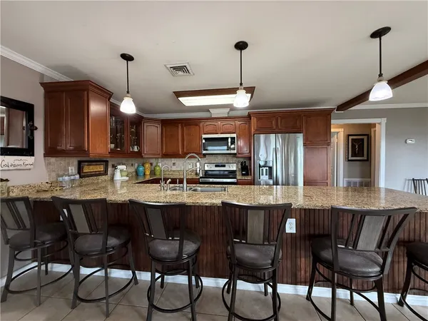 a kitchen with stainless steel appliances granite countertop a sink refrigerator and cabinets