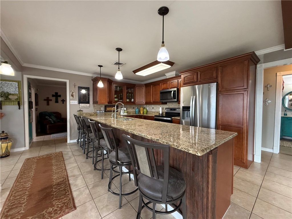 116 Sunset Drive Mathis, TX 78368 - Photo 21 of 40 a kitchen with stainless steel appliances granite countertop a sink refrigerator and cabinets
