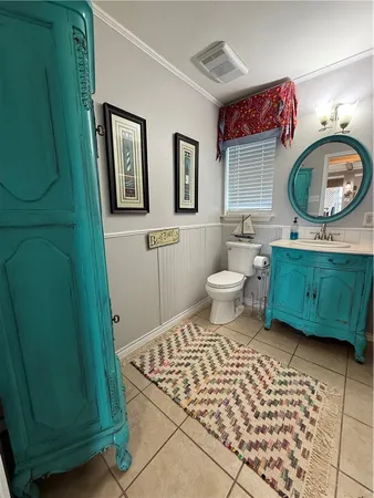 a bathroom with a toilet a sink and mirror