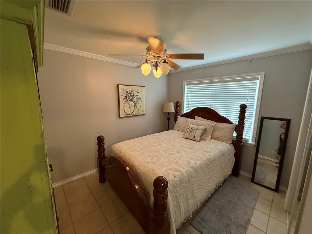 116 Sunset Drive Mathis, TX 78368 - Photo 29 of 40 a bedroom with a bed and a chandelier