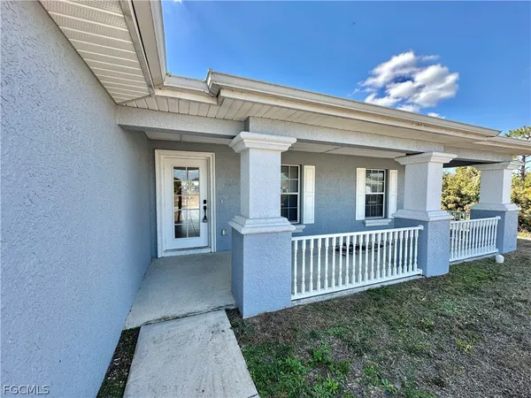a view of a porch with a table and chairs