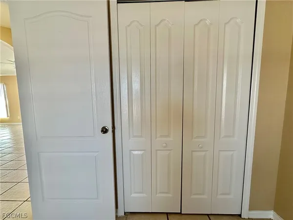 a view of a hallway with wooden floor and a bathroom