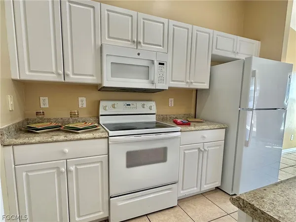 a kitchen with stainless steel appliances granite countertop white refrigerator stove a sink and dishwasher