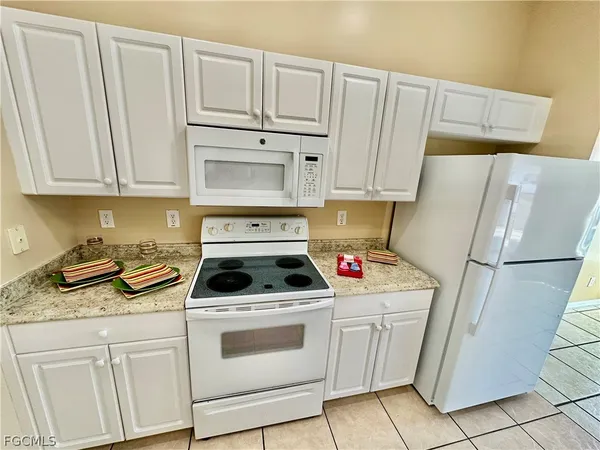 a kitchen with white cabinets and white appliances
