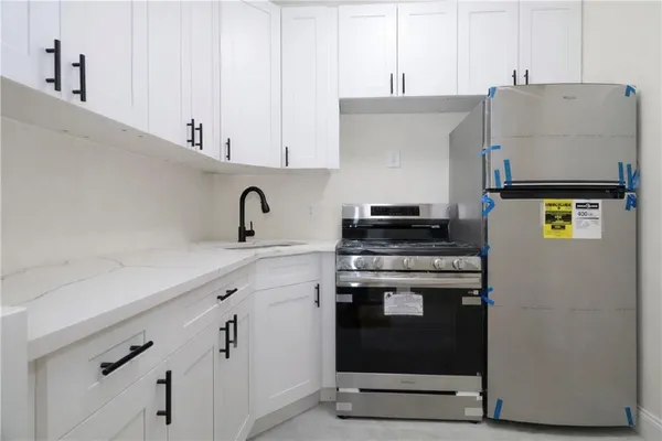 a kitchen with stainless steel appliances granite countertop a stove and a refrigerator