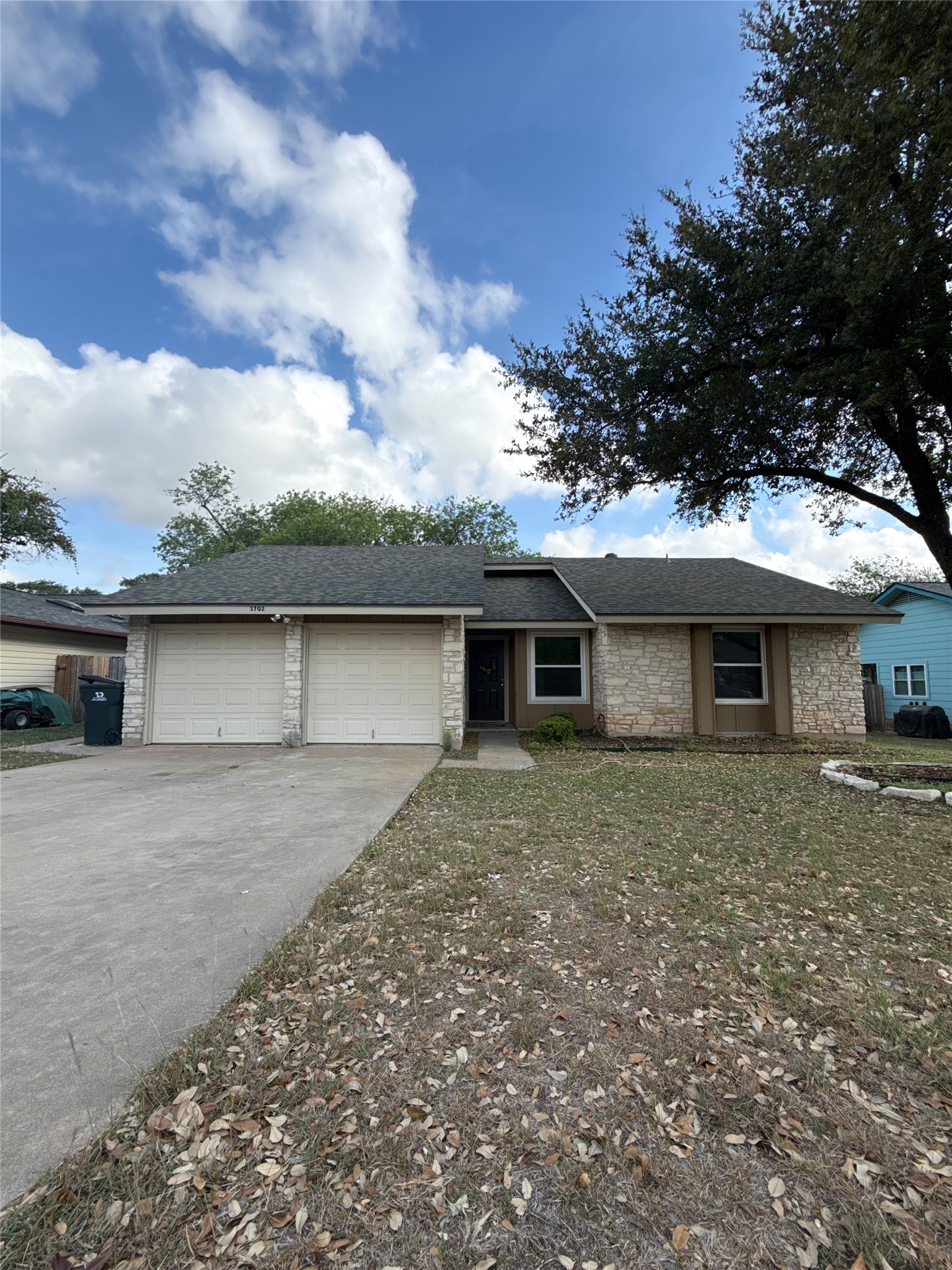 3702 Cornerstone Round Rock, TX 78681 - Photo 1 of 1 Ranch-style home with a garage, a shingled roof, stone siding, and driveway