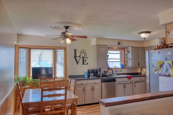 a kitchen with stainless steel appliances kitchen island granite countertop a refrigerator and a stove top oven