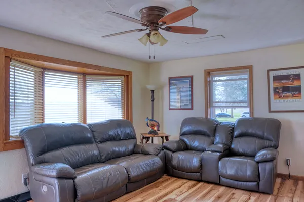 a living room with furniture a large window and a chandelier