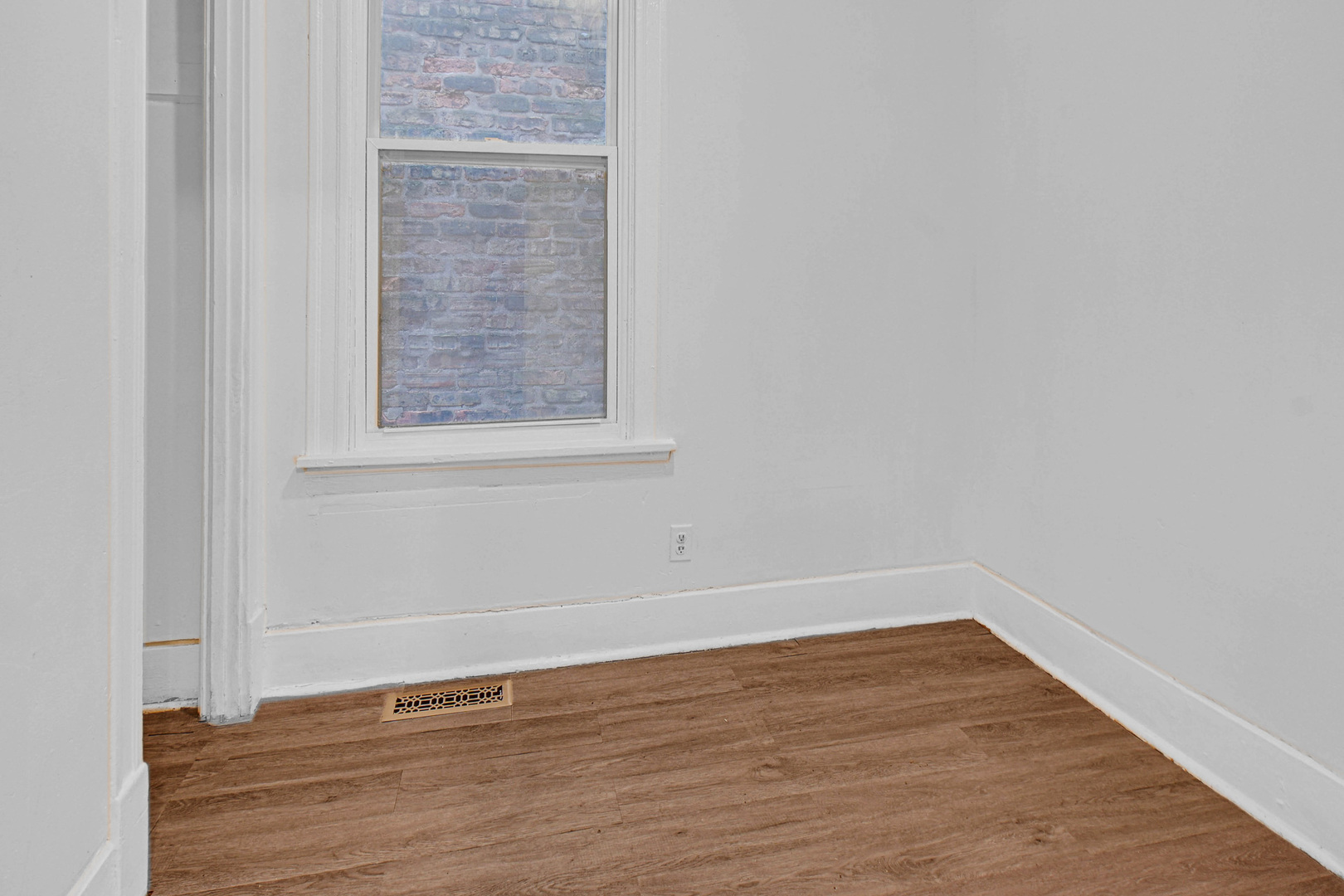 5607 South Laflin Street Chicago, IL 60636 - Photo 14 of 17 a view of an empty room with wooden floor and a window
