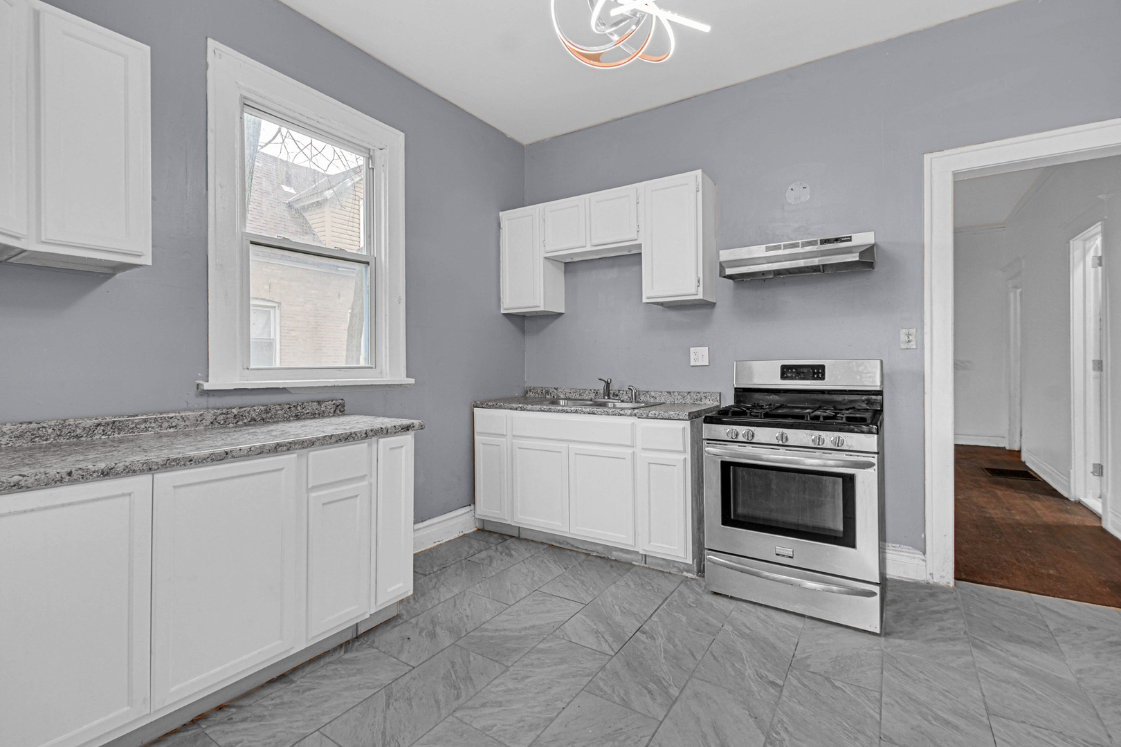 5607 South Laflin Street Chicago, IL 60636 - Photo 7 of 17 a kitchen with stainless steel appliances granite countertop a sink and a stove