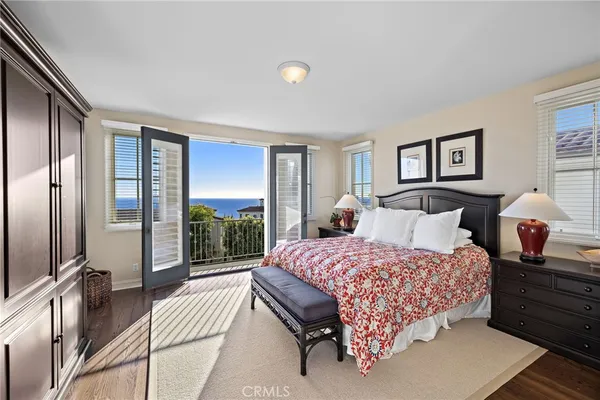 a bedroom with a bed lamp and a large window