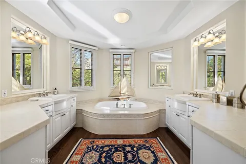 a spacious bathroom with a double vanity sink a mirror and a bathtub