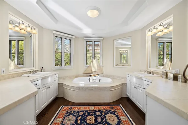 a spacious bathroom with a double vanity sink a mirror and a bathtub